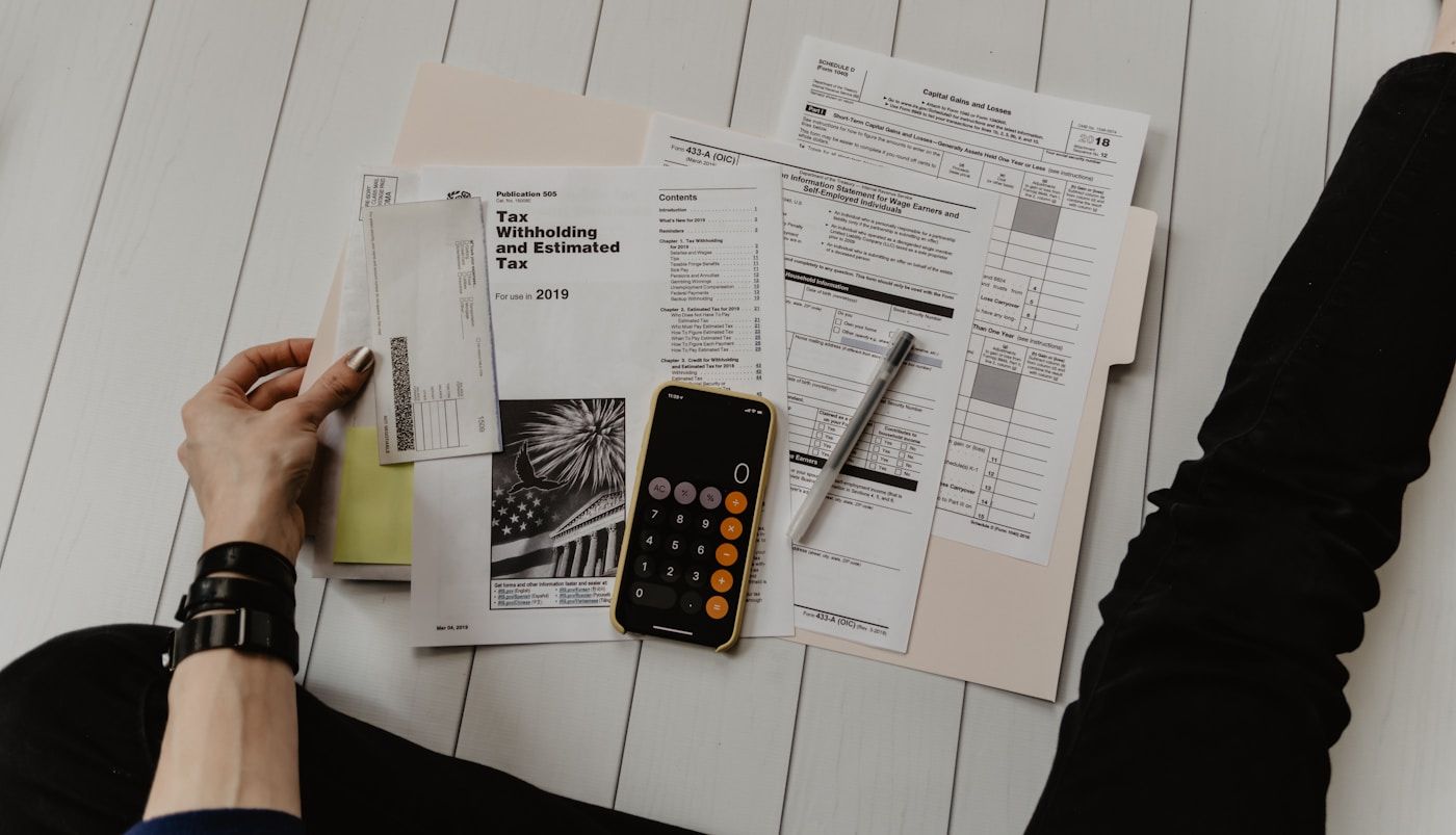 Facturas, formularios y una calculadora sobre un escritorio.
